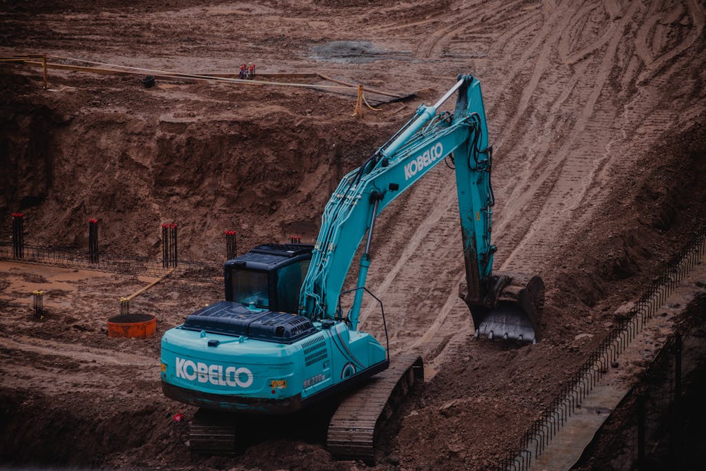 Blue excavator digging a pit at a construction site in Vilnius, Lithuania.
